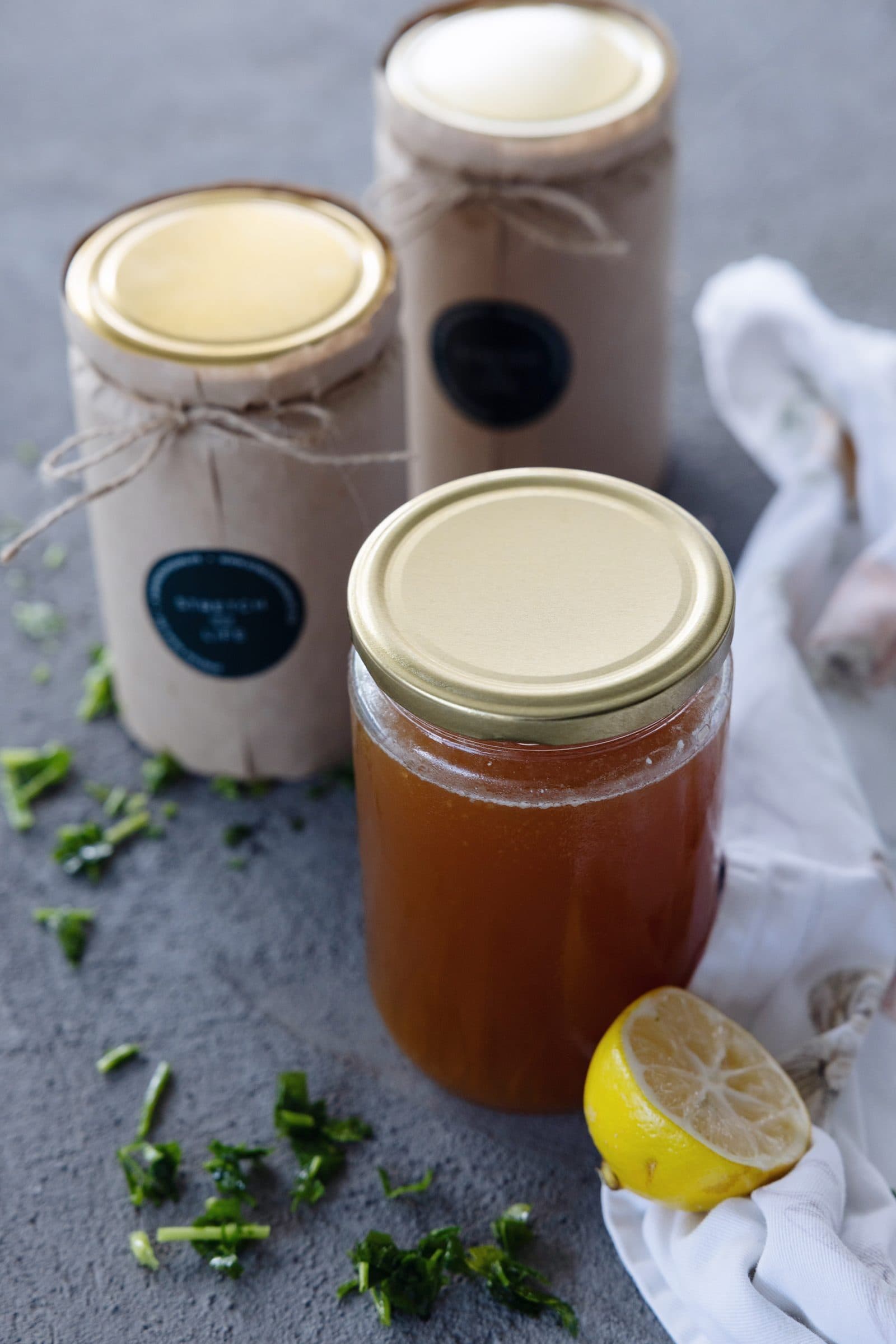 Kavanozda dana ilikli kemik suyu, yanında limon ve maydanoz